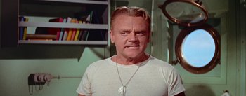 Movie still from “Mister Roberts” (1955), directed by John Ford – An older man wearing a white t - shirt and a necklace; Close Up shot, Low angle