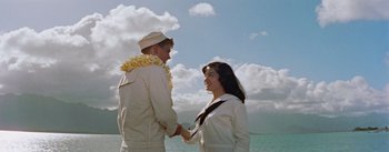 Movie still from “Mister Roberts” (1955), directed by John Ford – A man and a woman shaking hands on the beach; Wide shot, High angle