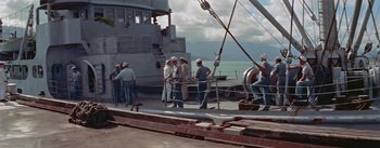 Movie still from “Mister Roberts” (1955), directed by John Ford – A group of men standing on the deck of a boat; Wide shot, High angle