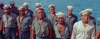 Movie still from “Mister Roberts” (1955), directed by John Ford – A group of men standing next to a body of water; Medium shot, Low angle