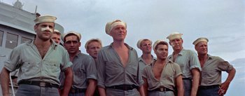 Movie still from “Mister Roberts” (1955), directed by John Ford – A group of men standing next to each other; Medium shot, Low angle