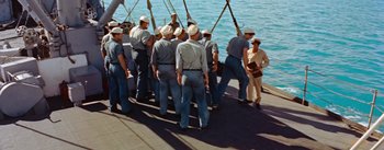 Movie still from “Mister Roberts” (1955), directed by John Ford – A group of men standing next to each other on a boat; Wide shot, High angle