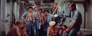 Movie still from “Mister Roberts” (1955), directed by John Ford – A group of men standing next to each other on some stairs; Medium shot, High angle