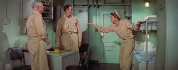 Movie still from “Mister Roberts” (1955), directed by John Ford – Two men in military uniforms point at each other in an office; Medium shot, High angle