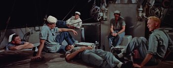 Movie still from “Mister Roberts” (1955), directed by John Ford – A group of men sitting on the deck of a boat; Wide shot, High angle