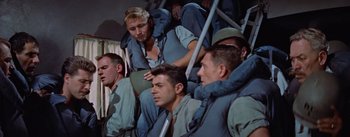 Movie still from “Mister Roberts” (1955), directed by John Ford – A group of men sitting next to each other on top of a bus; Medium shot, High angle