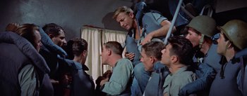 Movie still from “Mister Roberts” (1955), directed by John Ford – A group of men sitting around each other in a room; Medium shot, Low angle