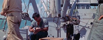 Movie still from “Mister Roberts” (1955), directed by John Ford – A man sitting on the deck of a boat; Medium shot, High angle