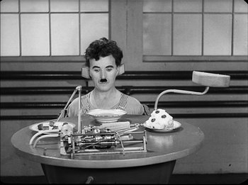 Movie still from “Modern Times” (1936), directed by Charles Chaplin – A woman sitting at a table in front of a plate of food; Medium shot, High angle
