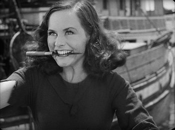 Movie still from “Modern Times” (1936), directed by Charles Chaplin – A black and white photo of a woman holding a cigar in her mouth; Medium shot, Low angle