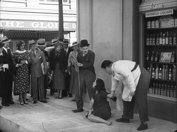 Movie still from “Modern Times” (1936), directed by Charles Chaplin – A group of people standing on the sidewalk; Wide shot, High angle