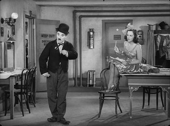 Movie still from “Modern Times” (1936), directed by Charles Chaplin – A man and a woman are standing in a living room; Wide shot, Low angle