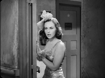 Movie still from “Modern Times” (1936), directed by Charles Chaplin – A black and white photo of a woman in a dress; Medium shot, Over the shoulder angle