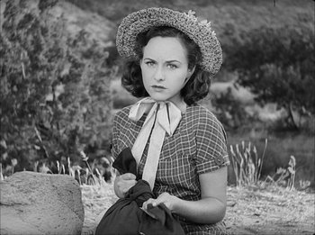 Movie still from “Modern Times” (1936), directed by Charles Chaplin – An old photo of a woman with a hat; Medium shot, High angle