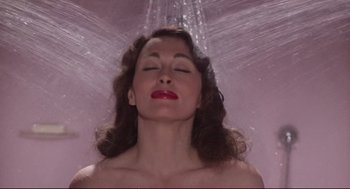 Movie still from “Mommie Dearest” (1981), directed by Frank Perry – A woman with her eyes closed under a shower; Close Up shot, High angle