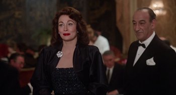 Movie still from “Mommie Dearest” (1981), directed by Frank Perry – A woman in a black dress and a man in a black suit; Medium shot, Over the shoulder angle