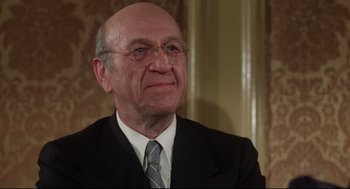 Movie still from “Mommie Dearest” (1981), directed by Frank Perry – An older man wearing a suit and tie; Close Up shot, Low angle