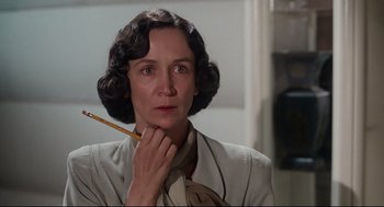 Movie still from “Mommie Dearest” (1981), directed by Frank Perry – An older woman holding a pencil in her mouth; Close Up shot, Over the shoulder angle