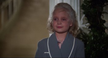 Movie still from “Mommie Dearest” (1981), directed by Frank Perry – A young girl wearing a robe and a tie; Close Up shot, High angle