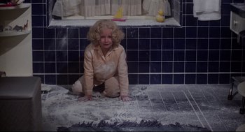 Movie still from “Mommie Dearest” (1981), directed by Frank Perry – A little girl sitting on the floor of a tiled bathroom; Wide shot, High angle