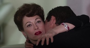Movie still from “Mommie Dearest” (1981), directed by Frank Perry – A man and a woman embracing each other; Close Up shot, Over the shoulder angle