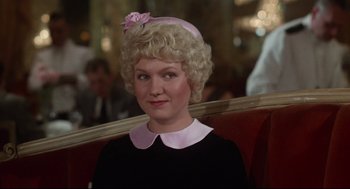 Movie still from “Mommie Dearest” (1981), directed by Frank Perry – A woman with blonde curly hair wearing a pink hat; Close Up shot, Over the shoulder angle