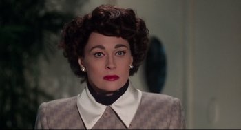 Movie still from “Mommie Dearest” (1981), directed by Frank Perry – An older woman wearing a jacket and a white shirt; Close Up shot, Low angle