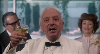 Movie still from “Mommie Dearest” (1981), directed by Frank Perry – An older man holding a glass of wine in his right hand; Close Up shot, Low angle