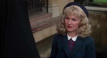 Movie still from “Mommie Dearest” (1981), directed by Frank Perry – A woman wearing a hat and a jacket; Close Up shot, Over the shoulder angle