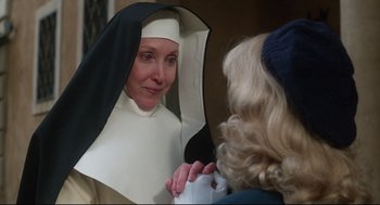 Movie still from “Mommie Dearest” (1981), directed by Frank Perry – A woman wearing a nun's outfit looking at another woman; Close Up shot, Over the shoulder angle