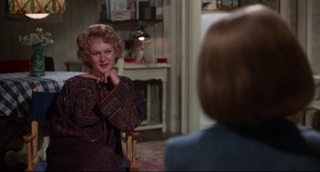 Movie still from “Mommie Dearest” (1981), directed by Frank Perry – A woman standing in front of another woman in front of a fireplace; Medium shot, Over the shoulder angle