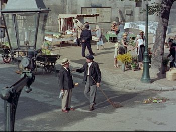Movie still from “My Uncle” (1958), directed by Jacques Tati – A group of people standing on the side of a road; Wide shot, High angle