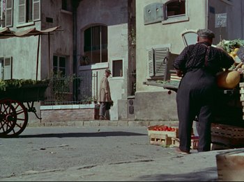 Movie still from “My Uncle” (1958), directed by Jacques Tati – An older man standing on the side of the street; Wide shot, High angle