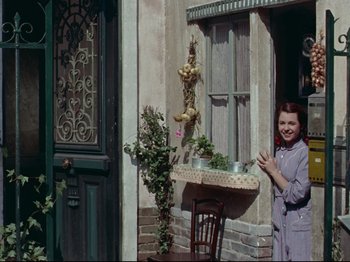 Movie still from “My Uncle” (1958), directed by Jacques Tati – A woman standing in front of a window; Wide shot, Low angle