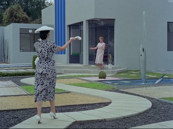 Movie still from “My Uncle” (1958), directed by Jacques Tati – Two women are playing a game of frisbee outside; Extreme Wide shot, Low angle