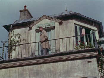 Movie still from “My Uncle” (1958), directed by Jacques Tati – A man standing on the balcony of a building; Wide shot, Low angle