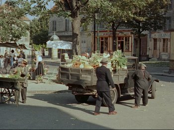 Movie still from “My Uncle” (1958), directed by Jacques Tati – A group of men standing next to each other near a truck; Extreme Wide shot, High angle