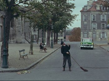 Movie still from “My Uncle” (1958), directed by Jacques Tati – A man sweeping the street with a broom in his hand; Extreme Wide shot, High angle