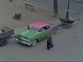 Movie still from “My Uncle” (1958), directed by Jacques Tati – An old car parked on the side of the street; Extreme Wide shot, High angle