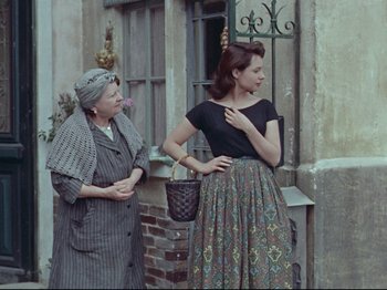 Movie still from “My Uncle” (1958), directed by Jacques Tati – Two women standing next to each other on the street; Medium shot, Over the shoulder angle