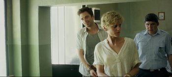 Movie still from “Monday” (2020), directed by Argyris Papadimitropoulos – A man and a woman standing next to each other in front of a mirror; Medium shot, Over the shoulder angle