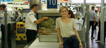 Movie still from “Monday” (2020), directed by Argyris Papadimitropoulos – A woman standing in front of a conveyor belt; Medium shot, Over the shoulder angle