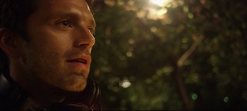 Movie still from “Monday” (2020), directed by Argyris Papadimitropoulos – A person wearing headphones near a tree; Close Up shot, Low angle