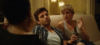 Movie still from “Monday” (2020), directed by Argyris Papadimitropoulos – A man and a woman sitting next to each other on a couch; Close Up shot, Over the shoulder angle