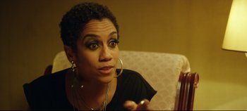 Movie still from “Monday” (2020), directed by Argyris Papadimitropoulos – A person sitting on a couch holding a cell phone; Close Up shot, Over the shoulder angle