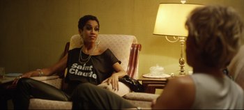 Movie still from “Monday” (2020), directed by Argyris Papadimitropoulos – A woman sitting in a chair in front of a lamp; Medium shot, Over the shoulder angle