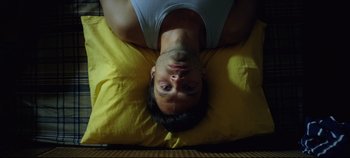 Movie still from “Monday” (2020), directed by Argyris Papadimitropoulos – A man laying on his stomach on a pillow; Close Up shot, Overhead angle