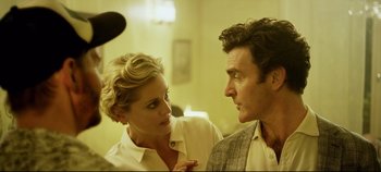 Movie still from “Monday” (2020), directed by Argyris Papadimitropoulos – A man and a woman standing next to each other in a room; Close Up shot, Over the shoulder angle