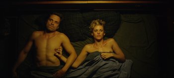 Movie still from “Monday” (2020), directed by Argyris Papadimitropoulos – A man and a woman laying in a bed together; Medium shot, Overhead angle
