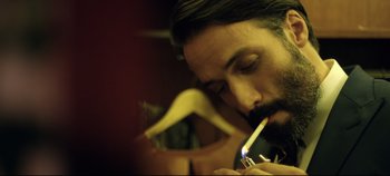 Movie still from “Monday” (2020), directed by Argyris Papadimitropoulos – A person lighting a cigarette; Close Up shot, Low angle